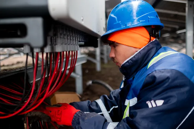 Technician inspecting cabling in an inverter cabinet